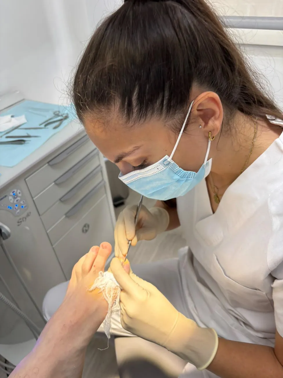 Podóloga de Impulso realizando una cirugía de uña encarnada con guantes y material estéril